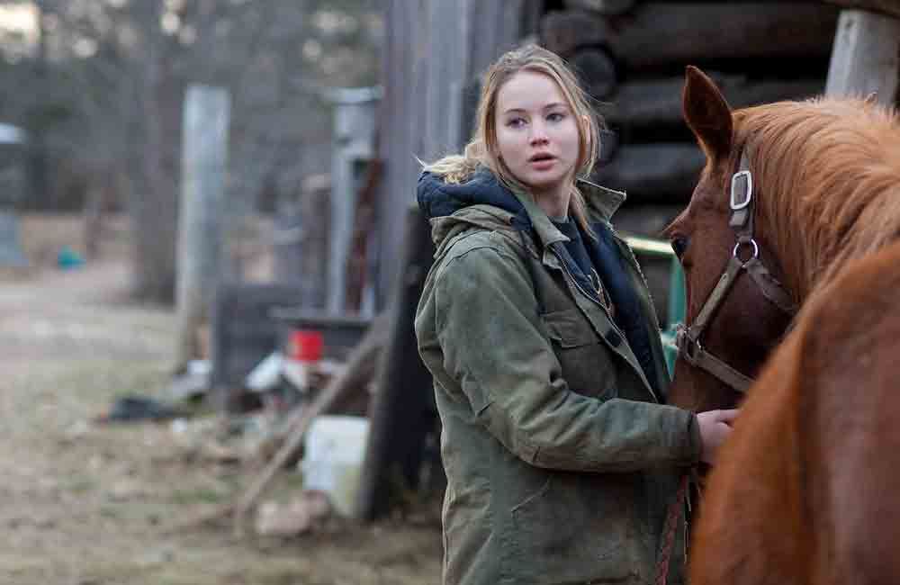 Jennifer Lawrence next to a horse in a scene from 'Winter's Bone' 