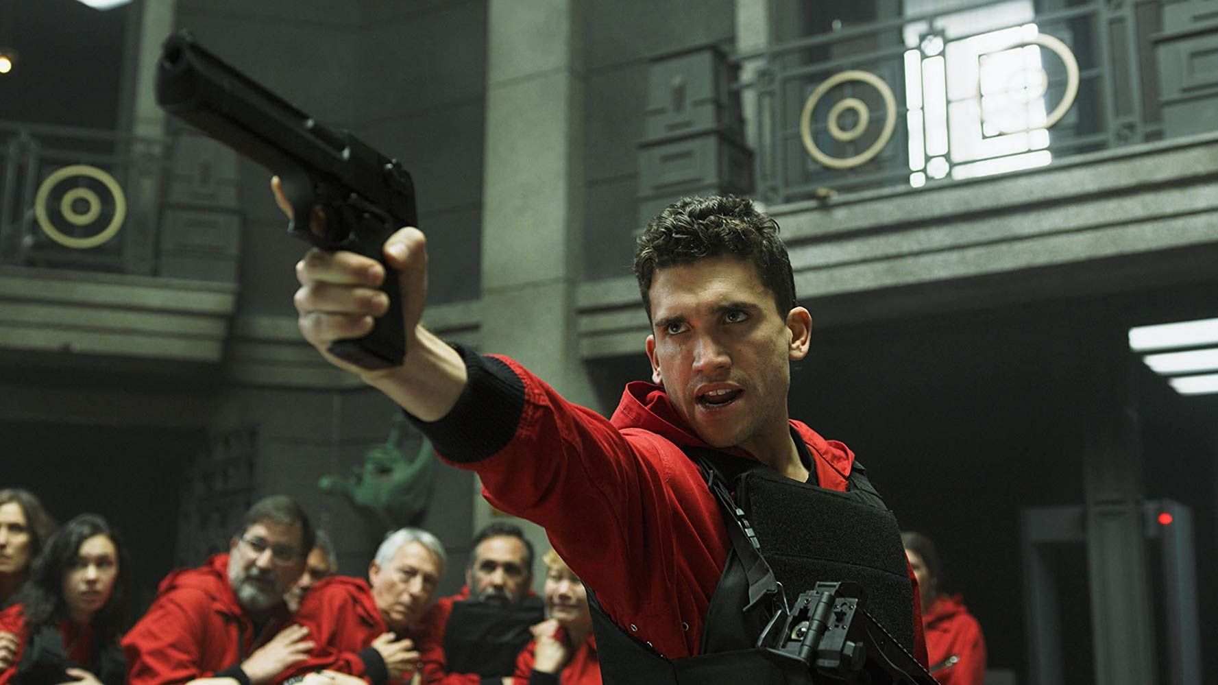 An action scene in Money Heist showing a character shooting a gun.