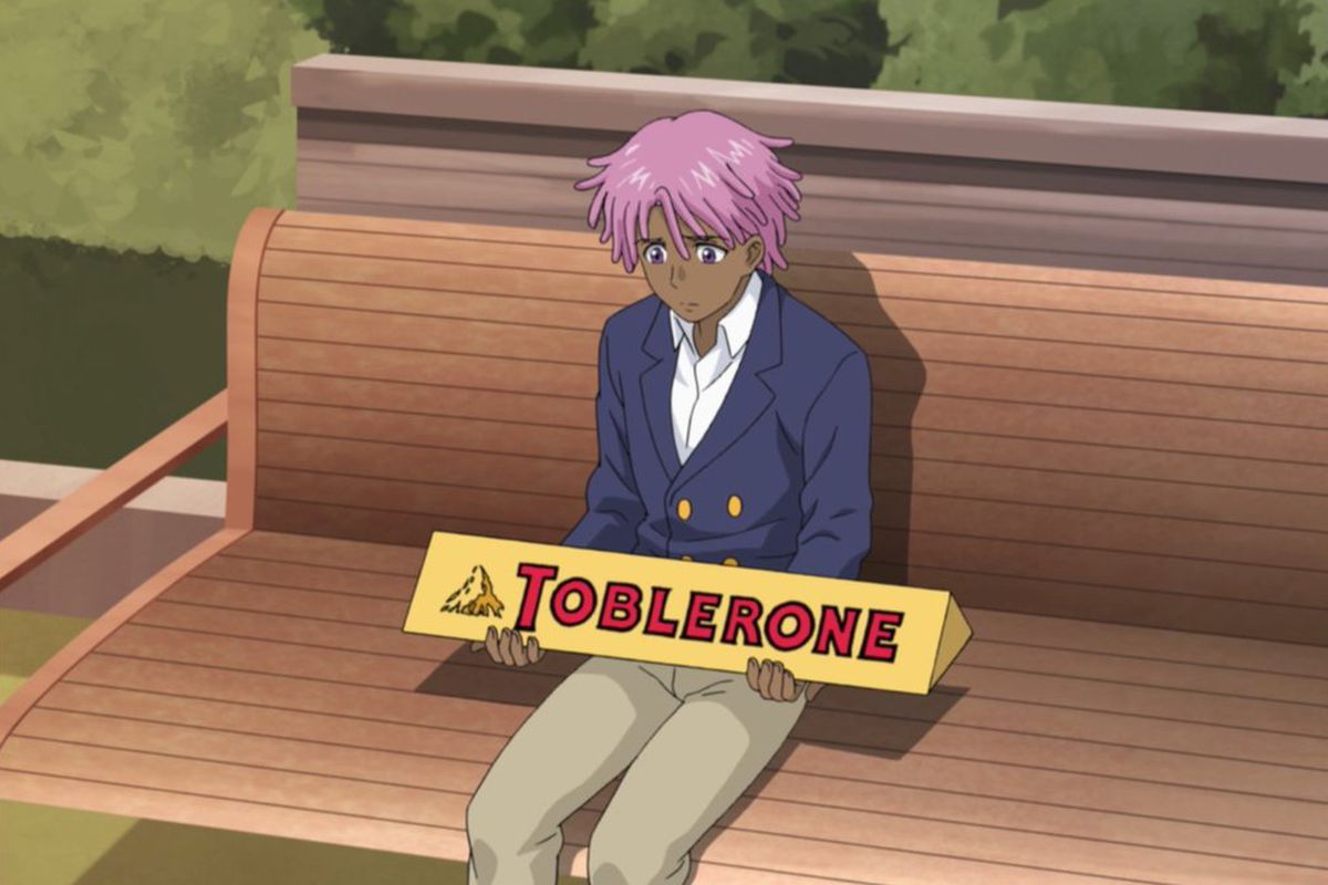 kazz kaan holding a big toblerone looking sad on bench