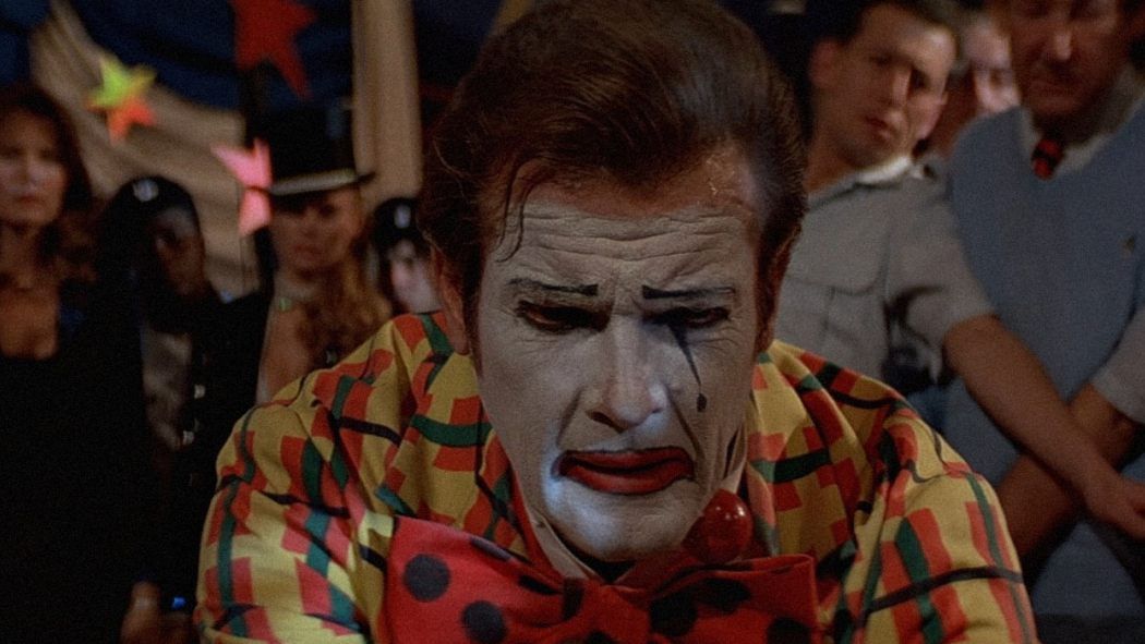 Roger Moore As A Clown Defusing a Bomb