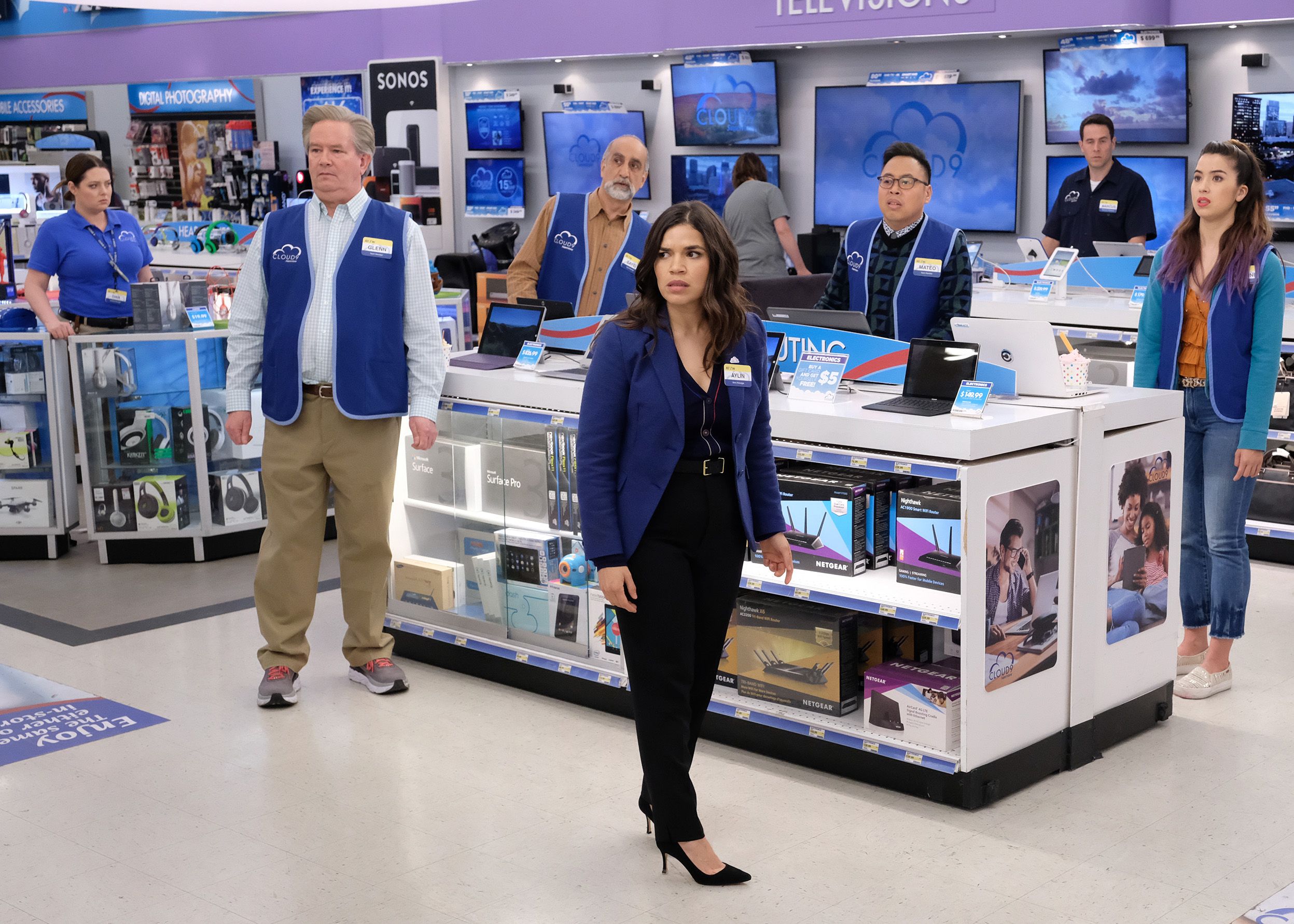 The Cast of Superstore on set in the electronic department
