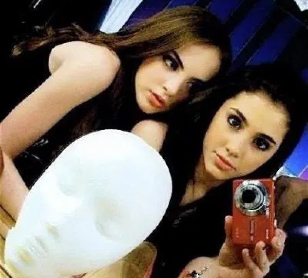 Young Ariana Grande holding red camera mirror selfie with a friend and foam head