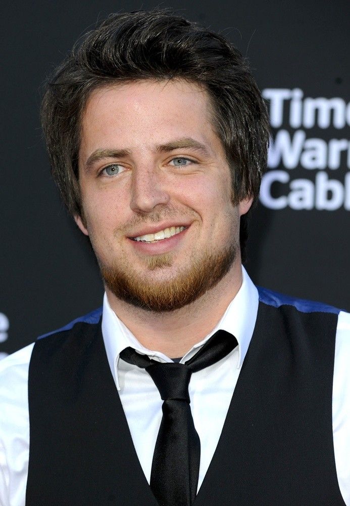 Lee DeWyze wearing a black vest over a white shirt and black neck tie