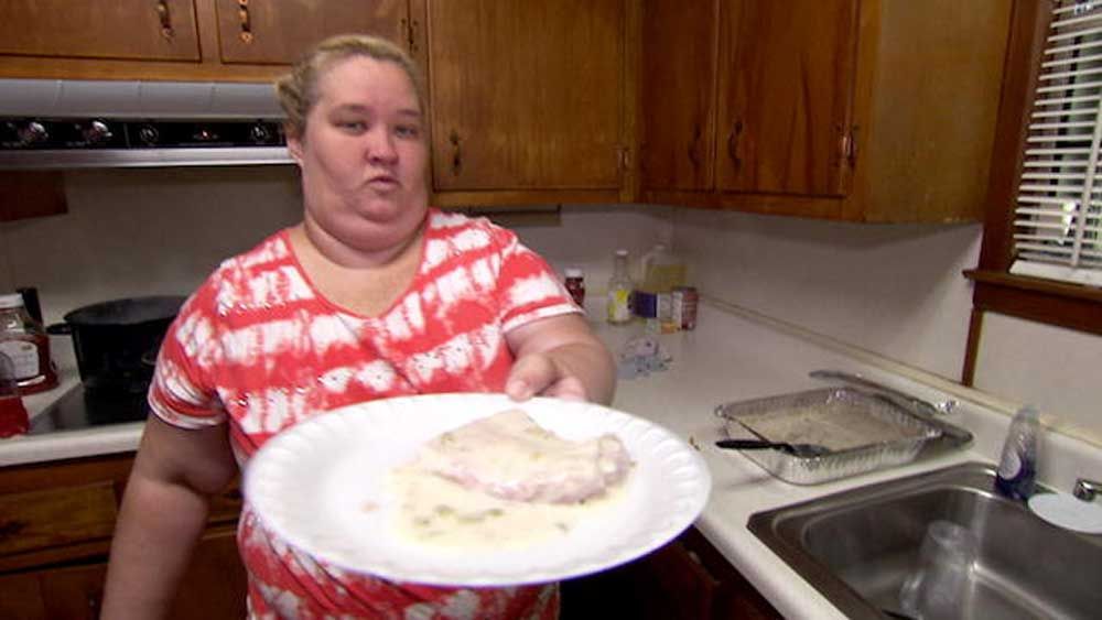 mama june standing in kitchen holding up plate
