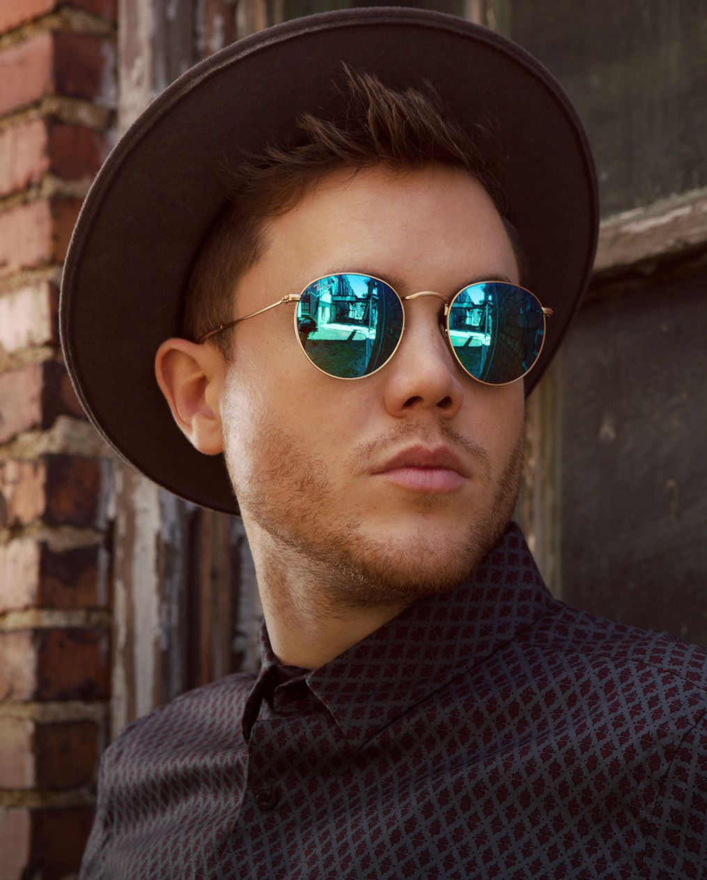 Trent Harmon wearing a fedora and sunglasses