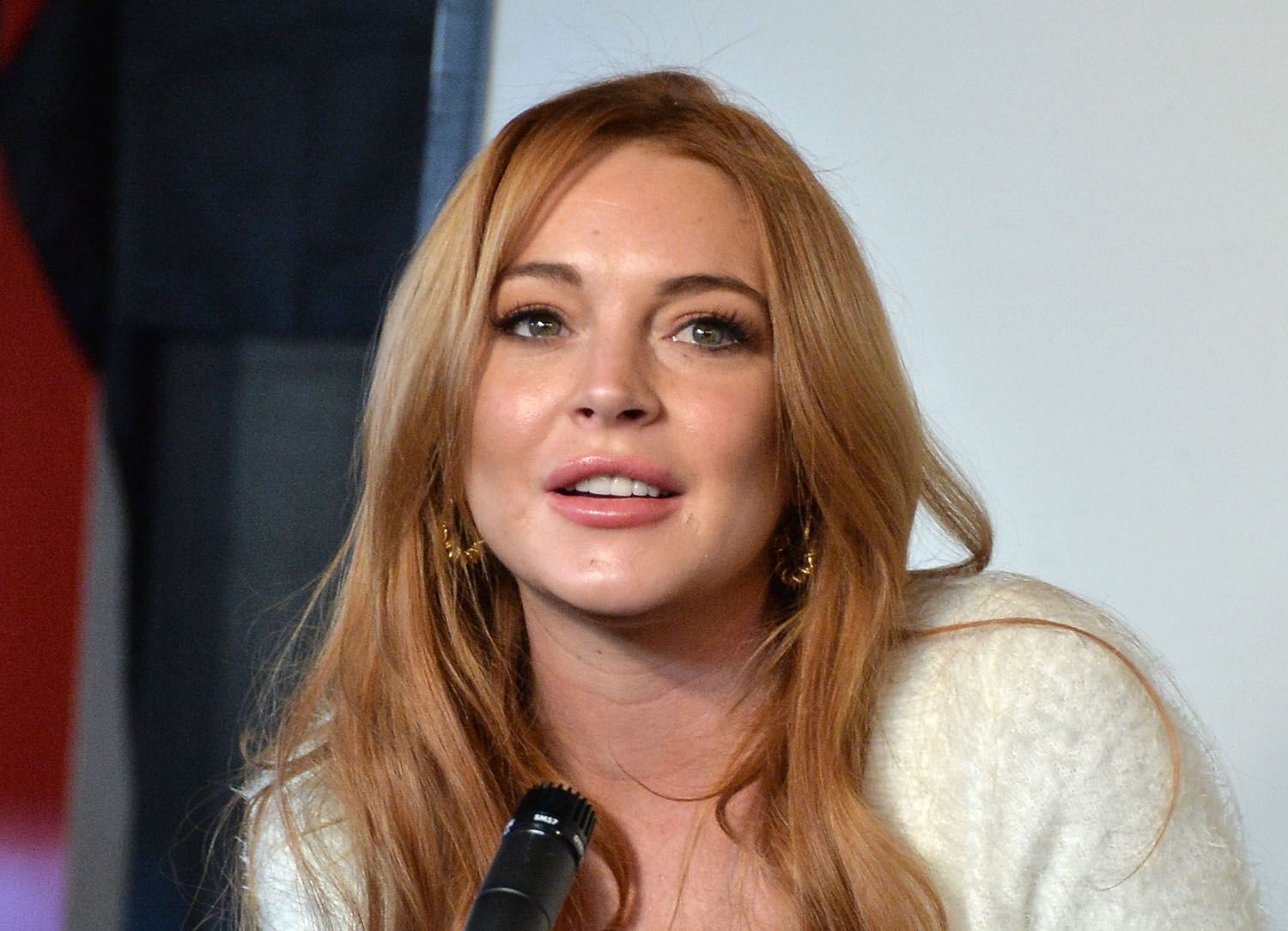 lindsay lohan sitting down being interviewed during press conference