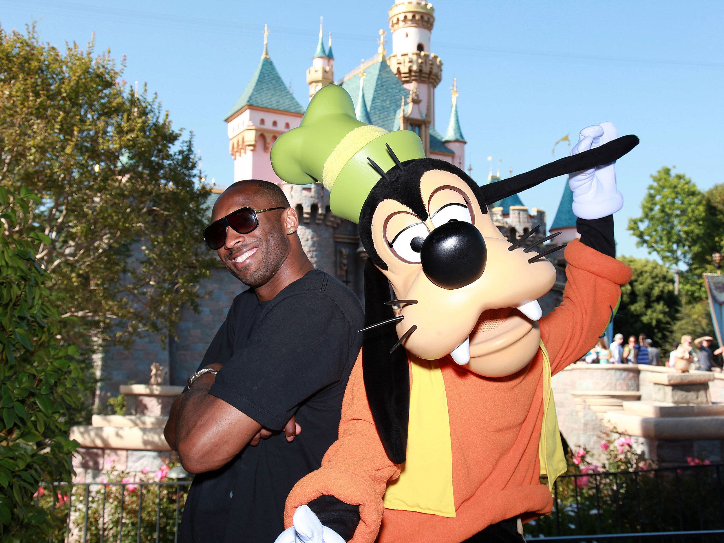 Kobe Bryant posing with Goofy at Disneyland. 