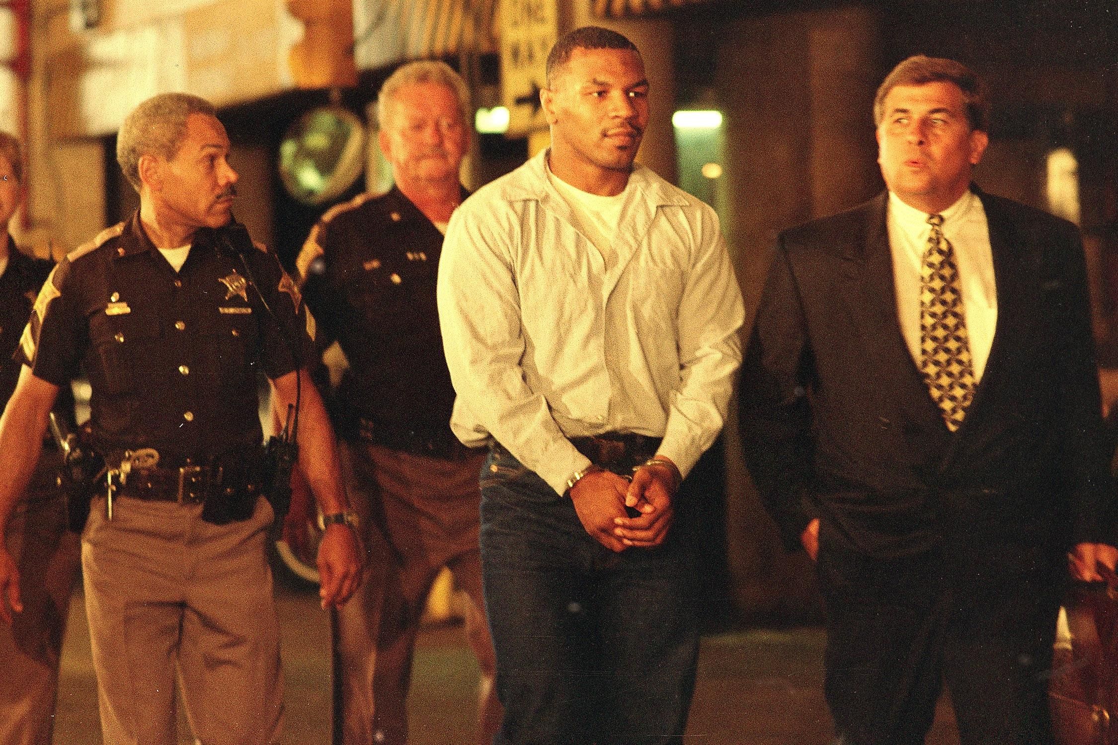 Mike Tyson being lead by police in his 1992 arrest
