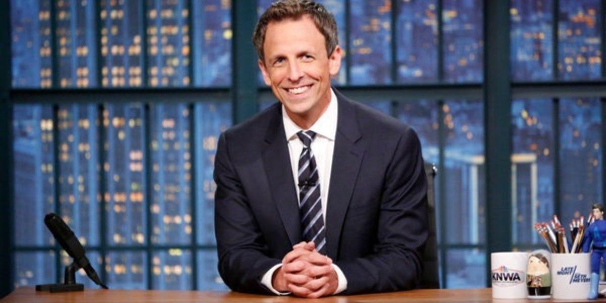 Seth Meyers sits at his Late Night desk