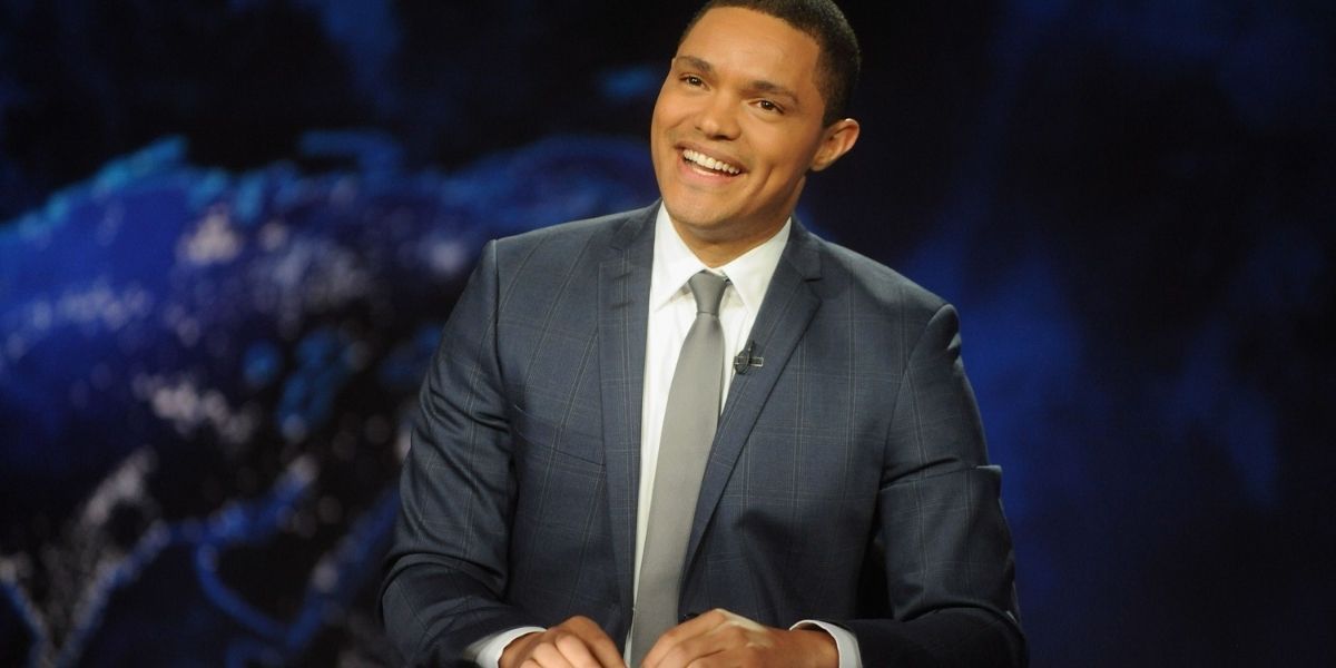 Trevor Noah at his desk on set of The Daily Show