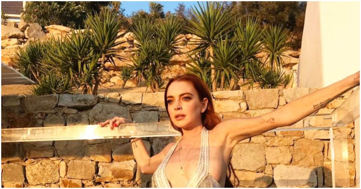 Lindsay Lohan posing magestically in front of a rock wall