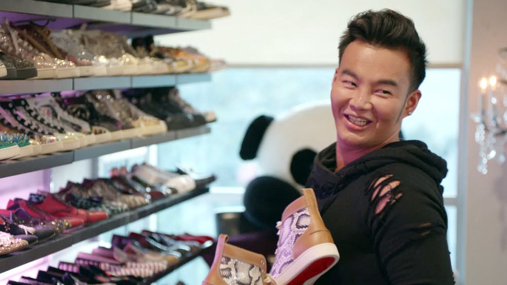 kane lim on reality show netflix bling empire standing in shoe closet holding up shoe