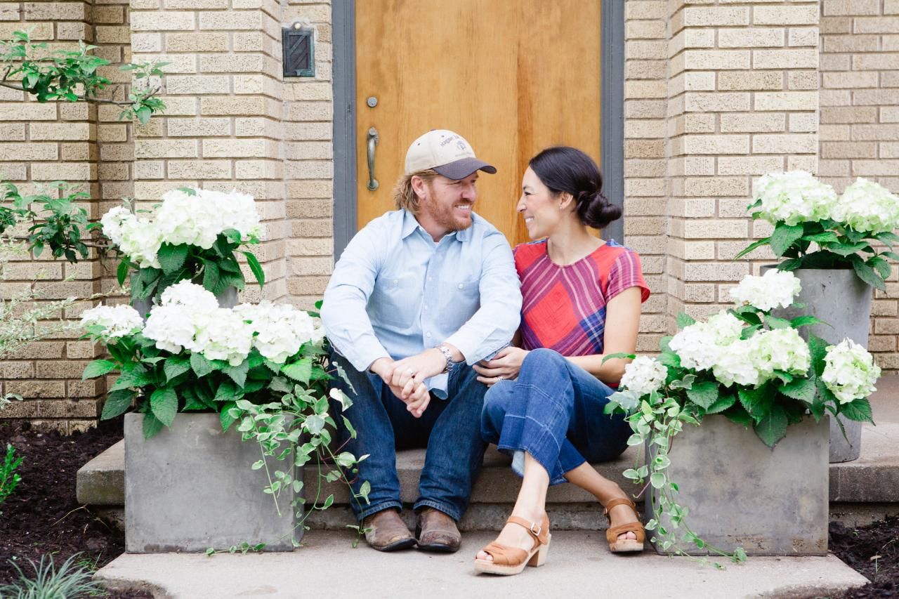 chip and joanna gaines sitting on front steps of house
