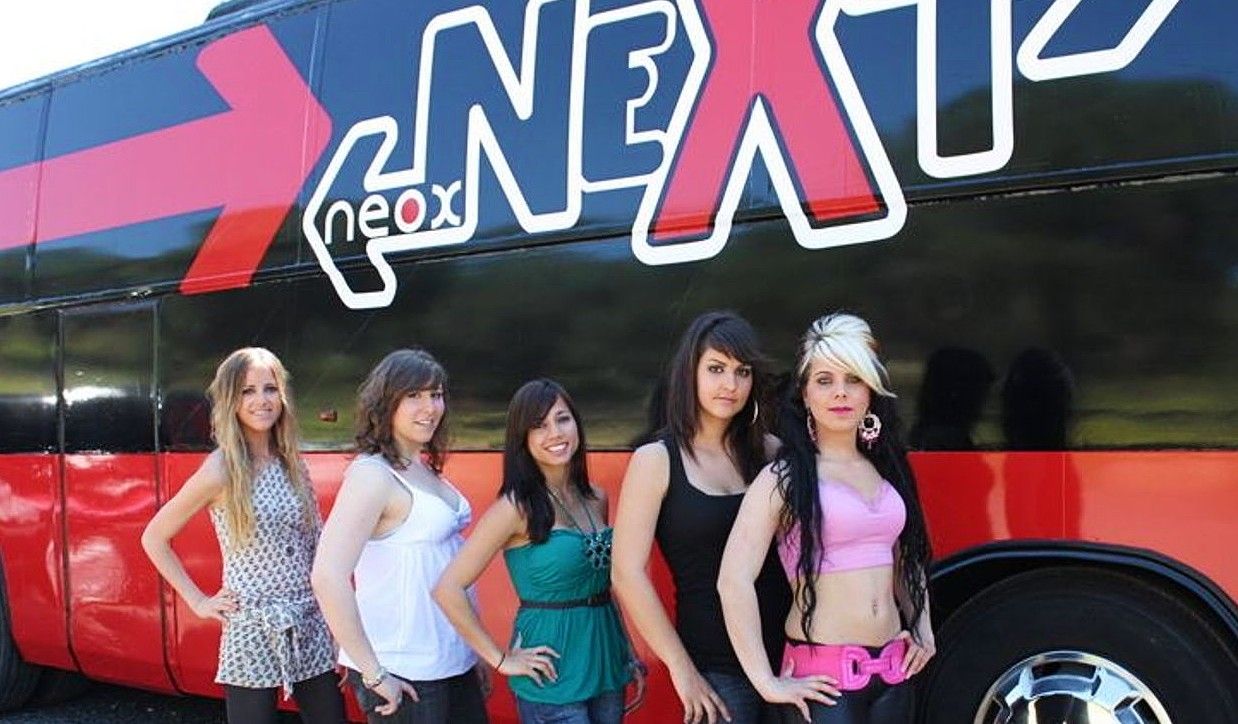 women standing in front of the Next bus