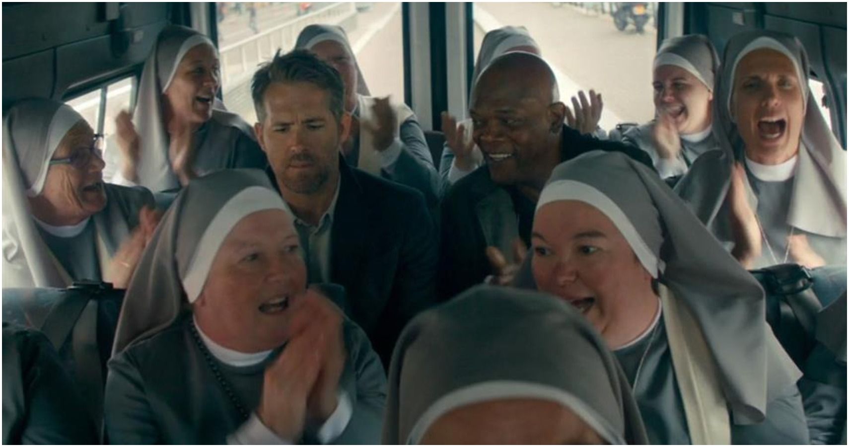 ryan reynolds and samuel l jackson sit on a bus surrounded by nuns