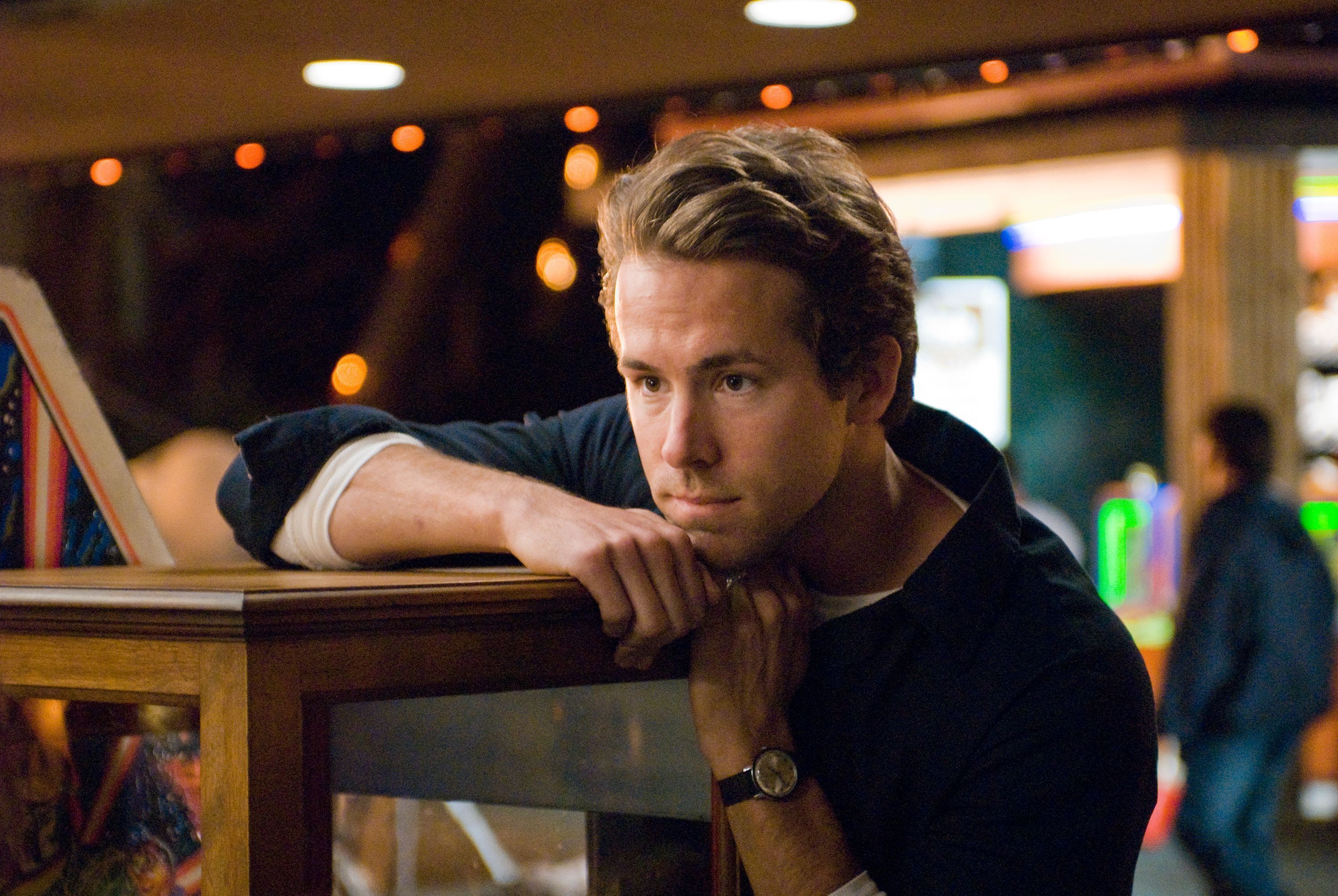 ryan reynolds leans on a table