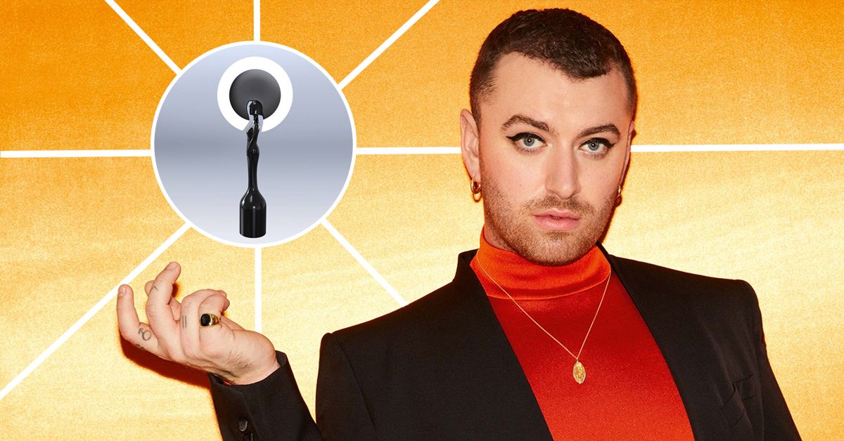 Sam Smith on yellow with hand out and BRIT Award trophy