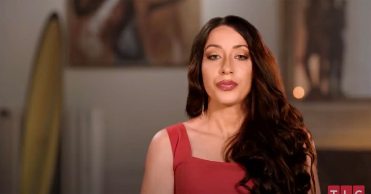 Amira talking on 90 Day Fiance and wearing a red dress.