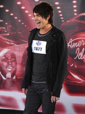 Adam Lambert singing at his American Idol audition and wearing a black hoodie, shirt, and pants.
