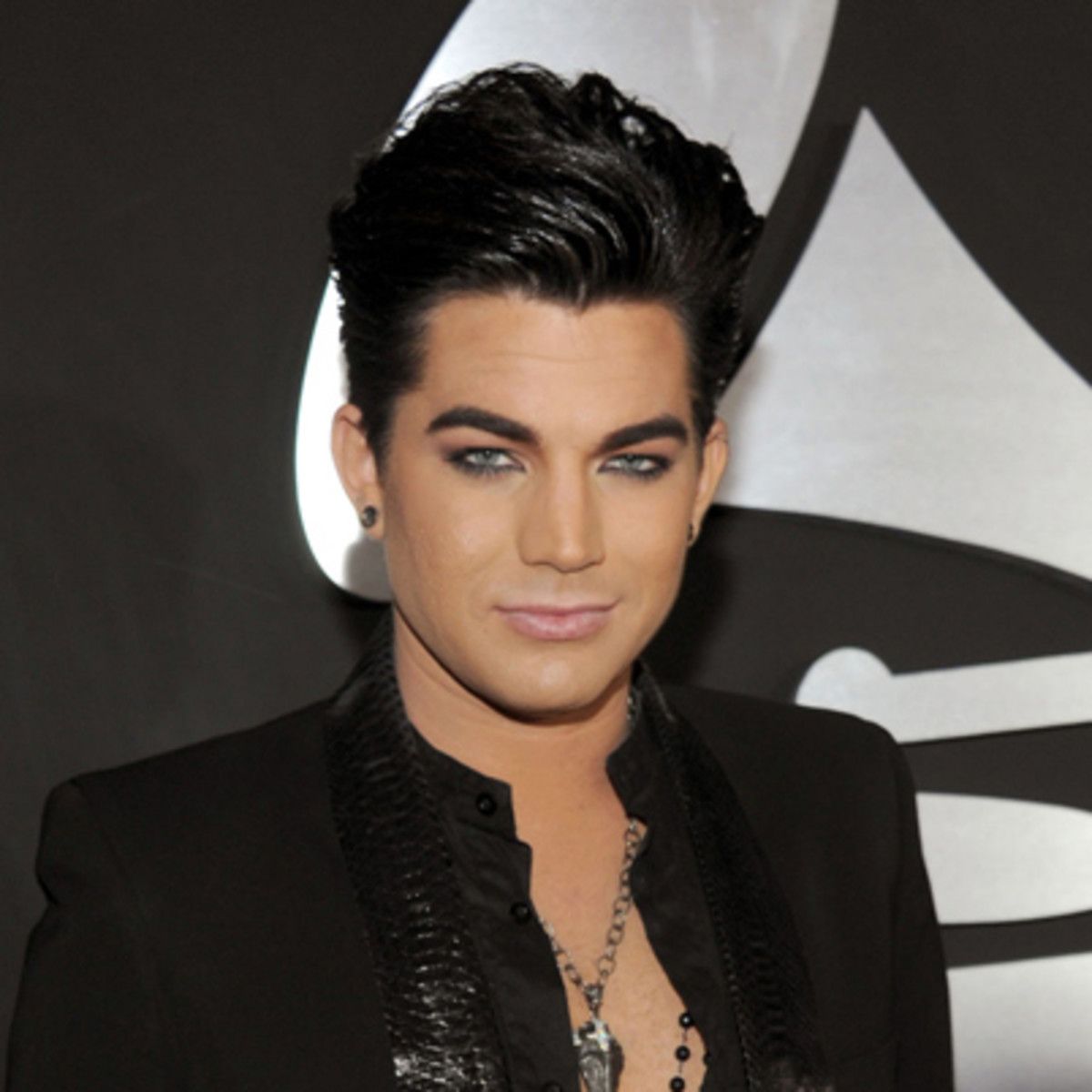 Adam Lambert wearing a black shirt and necklace at the Grammys.