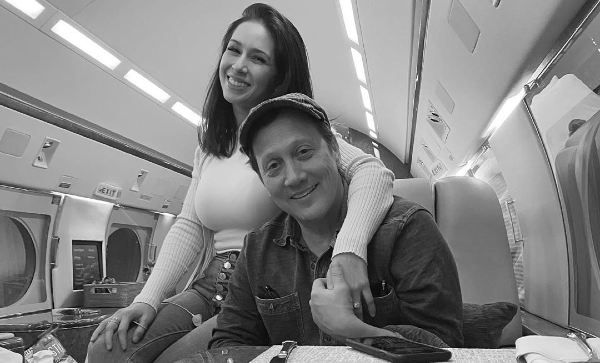 Black and white picture of Patricia putting her arm around Rob Schneider.