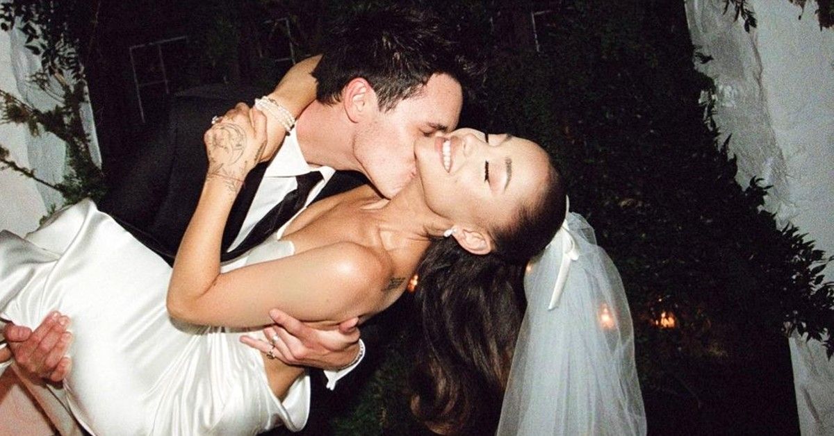 Ariana Grande in wedding dress carried and kissed by Dalton Gomez in tux
