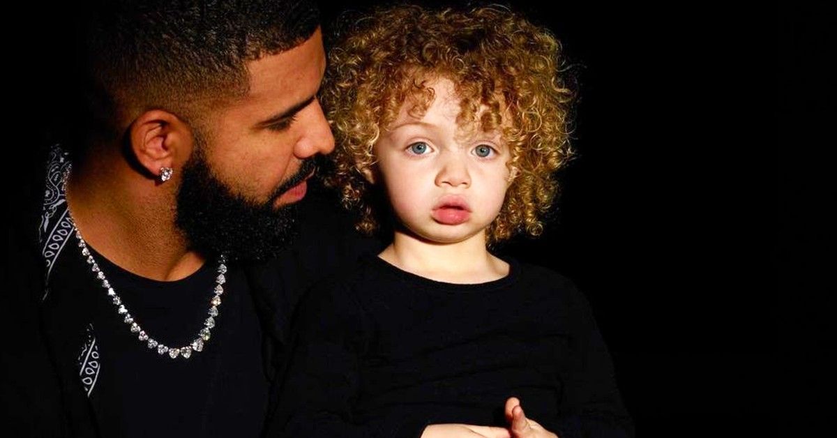 Drake and son Adonis in front of black backdrop