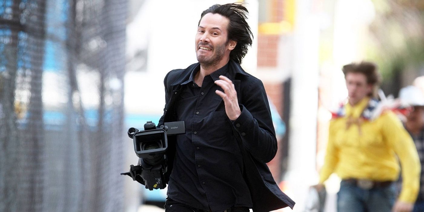 Keanu Reeves carrying a camera and running