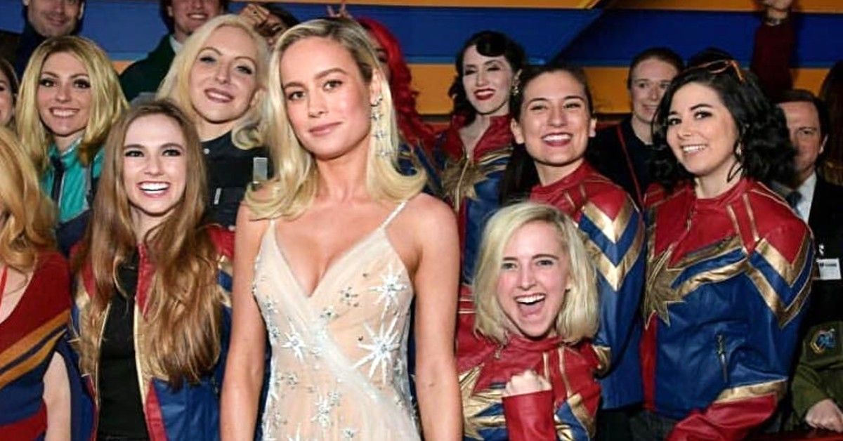 Brie Larson standing in front of girls dressed as Captain Marvel