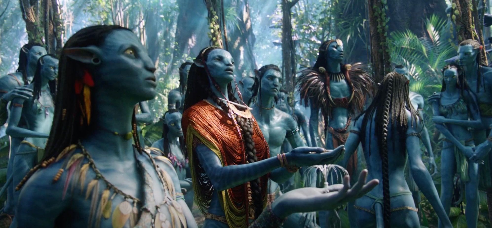 Sam Worthington with Neytiri and the rest of the Na'vi praying in a forest in Avatar.