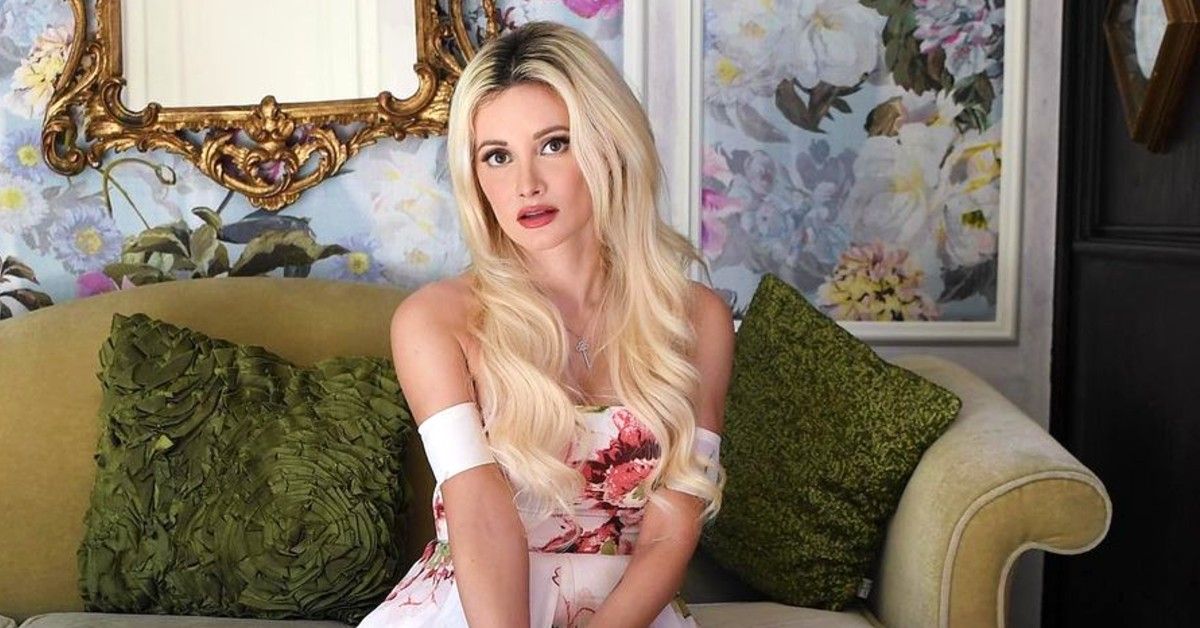 Holly Madison in white floral dress sitting on green couch