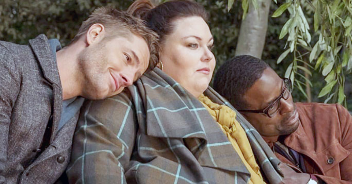 This Is Us: Justin Hartley with his head on Chrissy Metz, who's wearing a yellow scarf alongside Sterling K. Brown who also has his head on her shoulder.