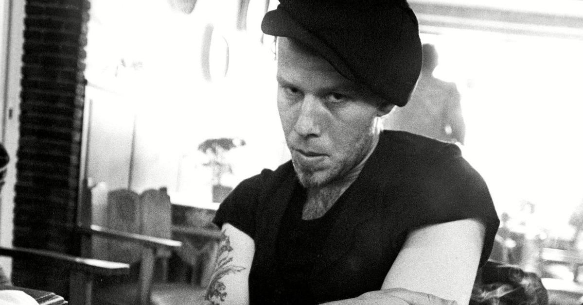Tom Waits stares at the camera in black and white