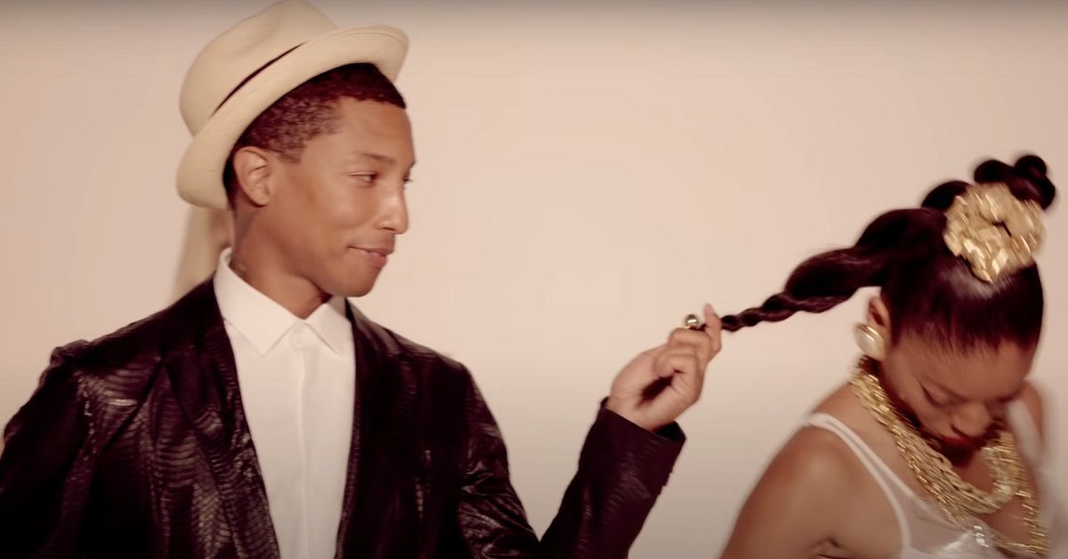 Pharrell Williams holds a woman's hair in the 'Blurred Lines' music video