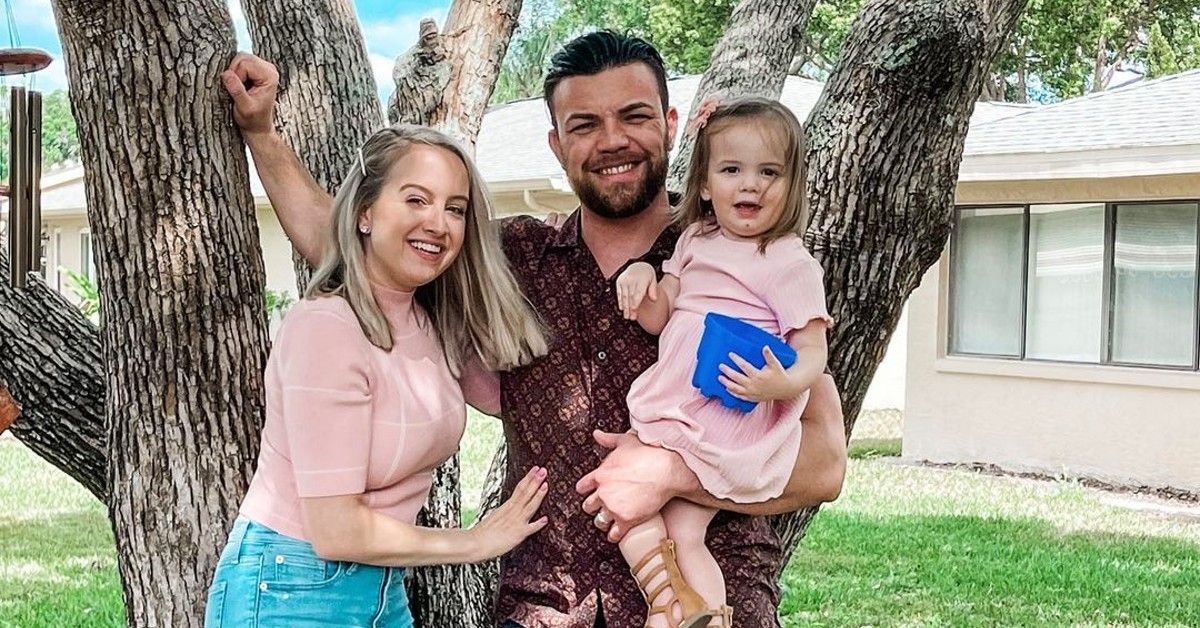 90 Day Fiance couple Elizabeth Potthast and Andrei Castravet with daughter in front of tree