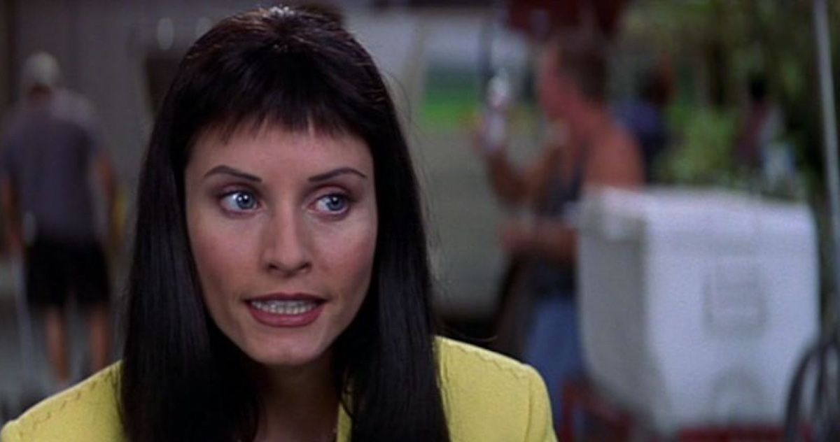 A close up of a short-fringed Courteney Cox as Gale Weathers wearing a yellow top in Scream 3.