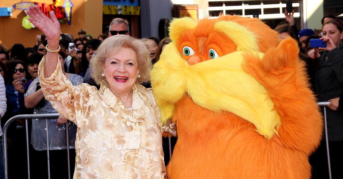 Betty White waving posed with Lorax at red carpet event