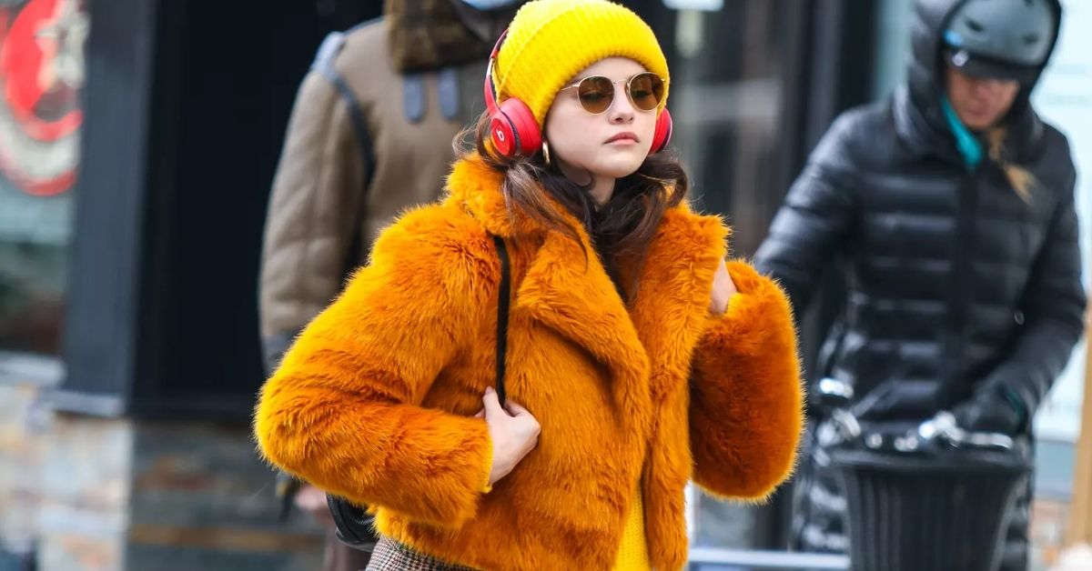 Selena Gomez as Mabel Mora in Only Murders In The Building walking wearing an orange coat