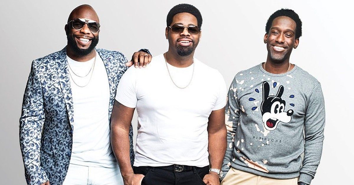 Members of Boyz II Men in grey and white clothes pose against white background