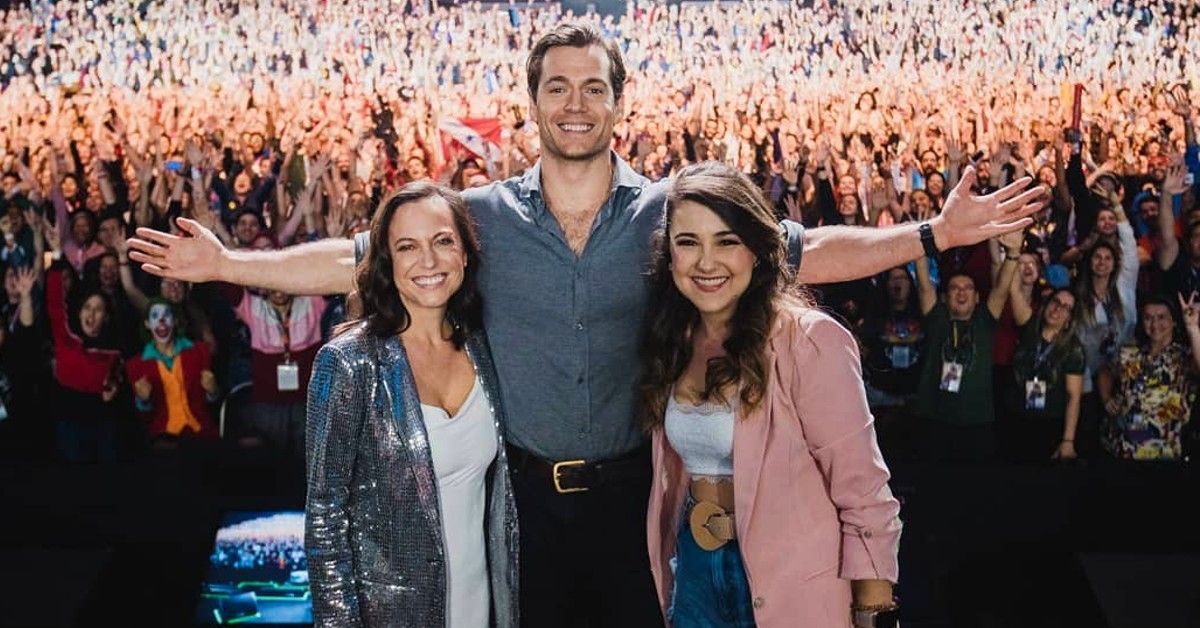 Henry Cavill poses with two ladies in front of large crowd