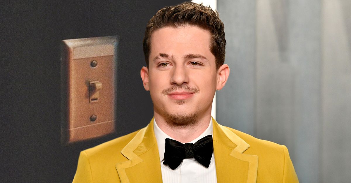 A lightswitch from Charlie Puth's Tiktok post promoting the release of his new music video (back), Charlie Puth wearing a yellow suit and a papillon while smirking (front)