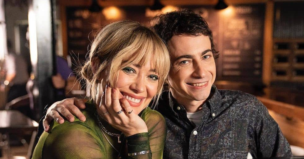 Hilary Duff and Adam Lamberg posing with a green top and smiling at the camera