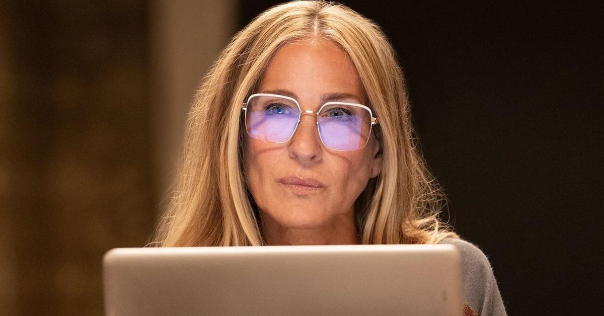 Sarah Jessica Parker as Carrie Bradshaw working on her laptop in a scene of And Just lIke That