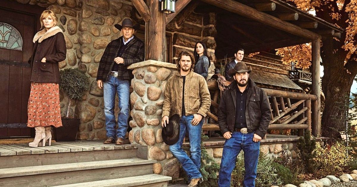 Cast of Yellowstone pose around western porch on Dutton Ranch