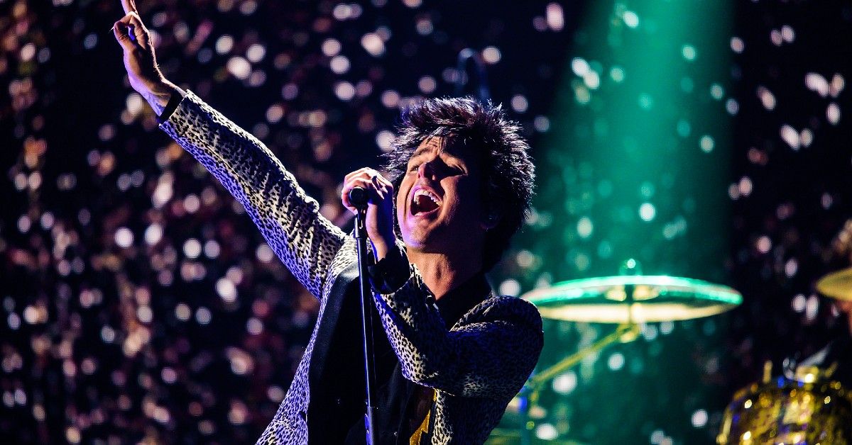 Billie Joe Armstrong performing on stage with lights