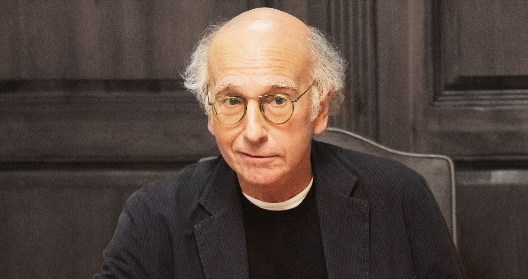 Larry David looking worried in a chair