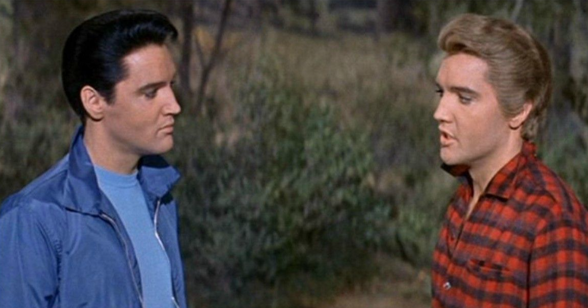Elvis Presley acting alongside himself in a movie, on the left he has black hair and a blue jacket, and on the right he has blonde hair and a red shirt.