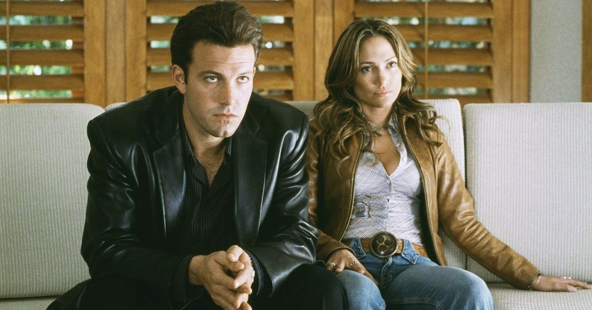 Ben Affleck and Jennifer Lopez sitting on couch wearing leather jackets in Gigli 