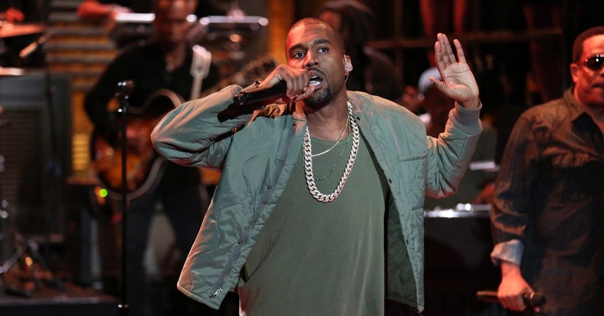 Kanye West performing with his hands up