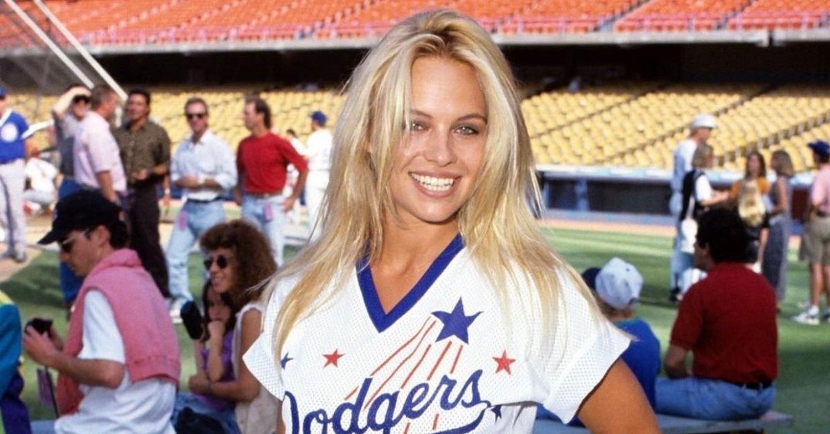 young Pamela Anderson on the field at a baseball stadium